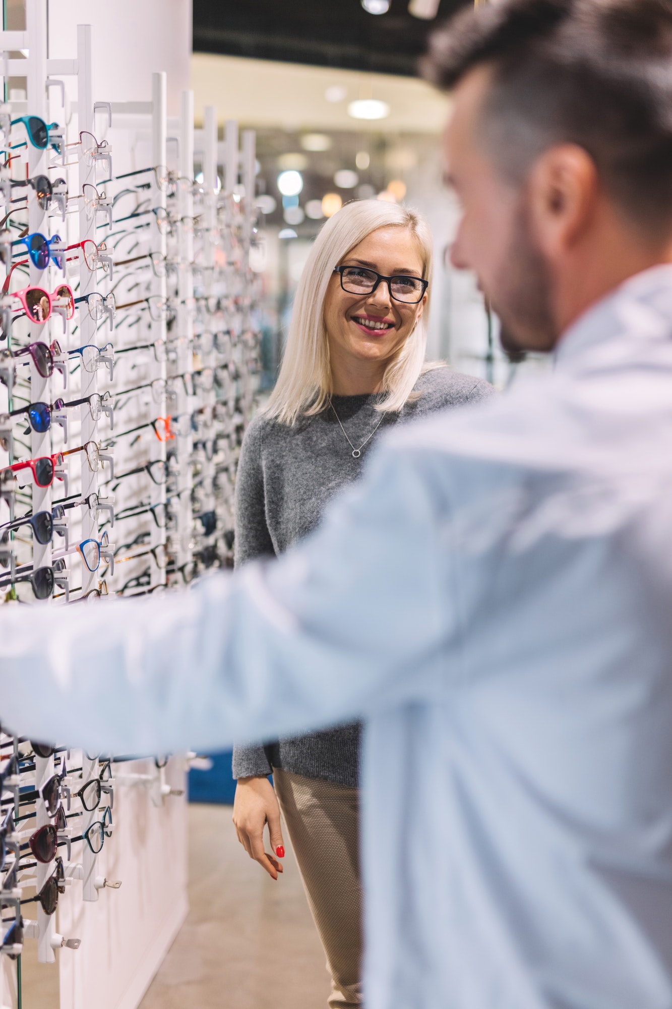 Woman and optician choosing glasses